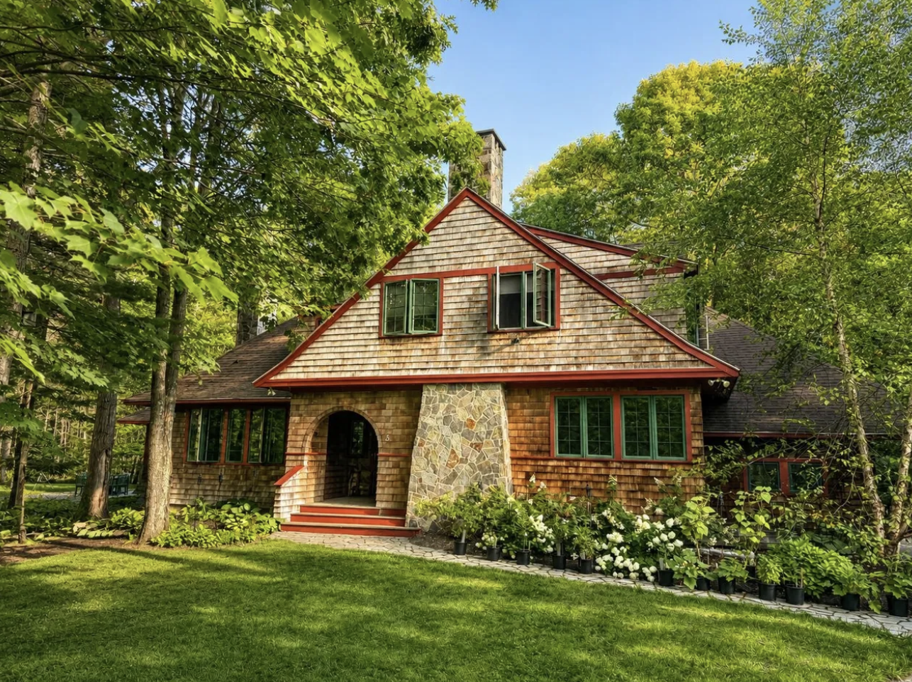 Cedar shingle Kennebunkport cottage with green trim, stone entryway, and mature landscaping